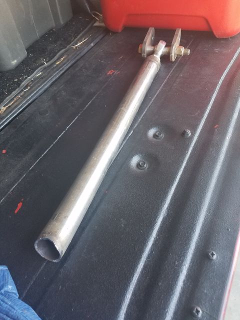 1968 Ford Bronco - A metal rod with a clevis joint at one end is resting on the black bedliner of a vehicle. The rod appears to be a part for a vehicle modifi…