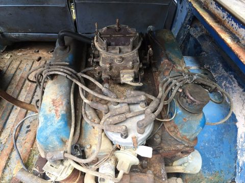 1967 Ford Bronco - Close-up view of a V8 engine, likely removed from a vehicle, showing the carburetor and distributor.