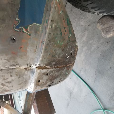 1967 Ford Bronco - This is a close-up, angled view of the lower rear corner of a vehicle body, likely a 1967 Ford Bronco, showing significant rust damage and…
