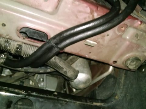 2002 Pontiac Grand Prix - This image shows a close-up view of the engine bay of a vehicle, focusing on black hoses and metal components. The hoses appear to be part…