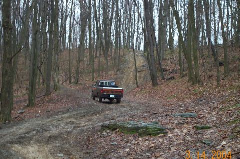 1986 Ford Bronco - Shaun's Ranger going up the Hill with aroot in the filthy way.