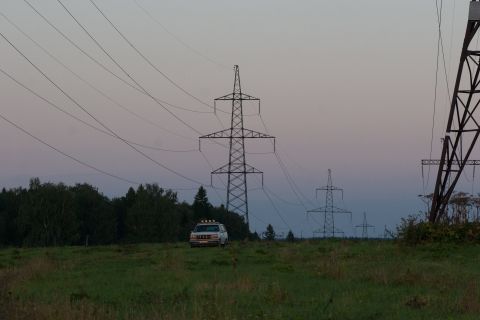 1993 Ford Bronco - A white 1993 Ford Bronco is parked in a grassy field with power lines and transmission towers in the background during twilight.
