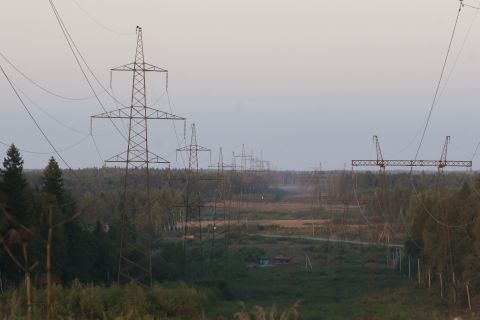 1993 Ford Bronco - A landscape scene with multiple tall power line towers stretching into the distance across a wooded area and open fields.
