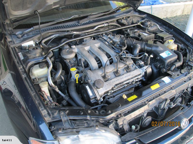 Engine bay of a dark blue 1993 Mazda MX-3.