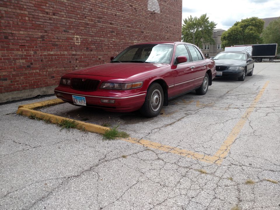 Red 1995 Mercury Grand Marquis parked in a lot.
