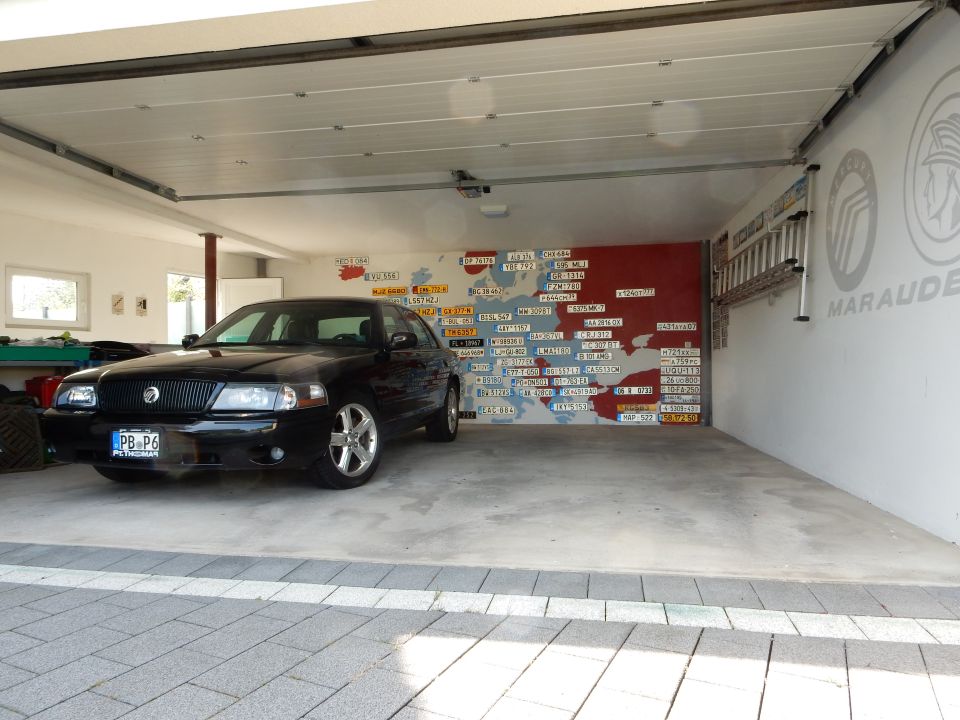 Black 2003 Mercury Marauder parked in a garage with a map mural on the wall