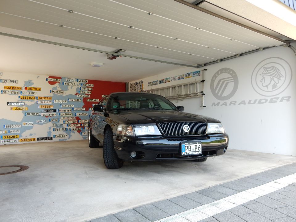 Black 2003 Mercury Marauder parked in a garage with a map of Europe decorated with license plates on the wall