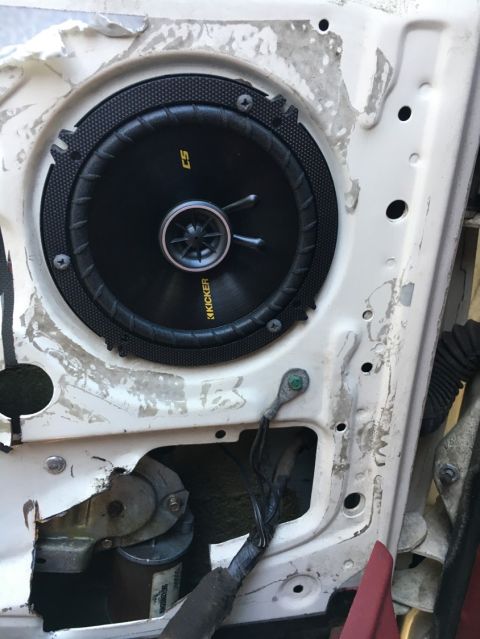 1988 Ford Bronco - Aftermarket Kicker speaker installed in a vehicle's door panel, showing wiring and internal components.