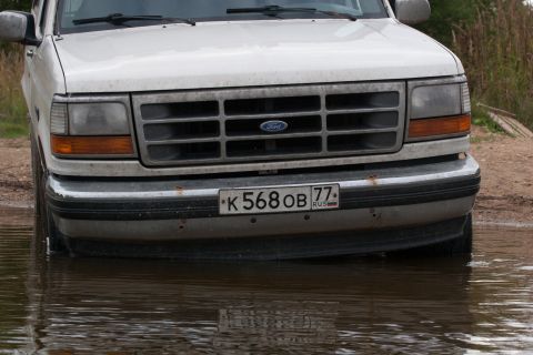 1993 Ford Bronco - Front view of a 1993 Ford Bronco driving through shallow water.