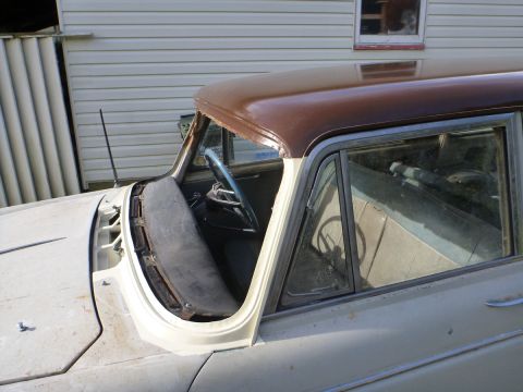 1962 MG B - A car's interior and roof are visible, with the windshield removed and a brown roof.