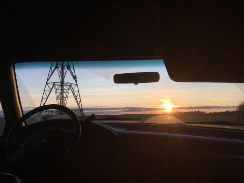 1993 Ford Bronco - View from inside a vehicle at sunset, with a power line tower in the distance.