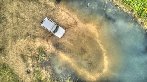 1993 Ford Bronco - An SUV navigates a watery, off-road terrain from an aerial perspective.
