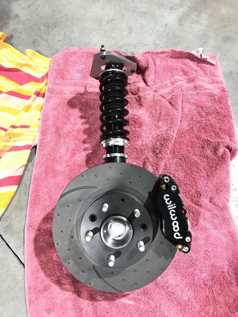 1973 Mazda RX-3 - A performance brake assembly, a Wilwood caliper and a drilled rotor, is laid out on a towel.