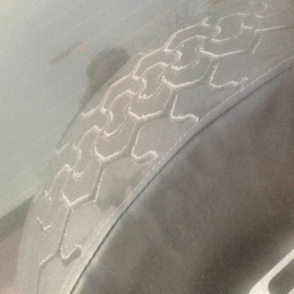 Spare tire cover with hexagonal tread pattern. Supermotors.net logo visible