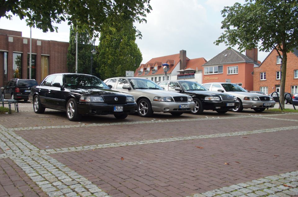 Black 2003 Mercury Marauder parked in front of brick buildings, with other cars nearby