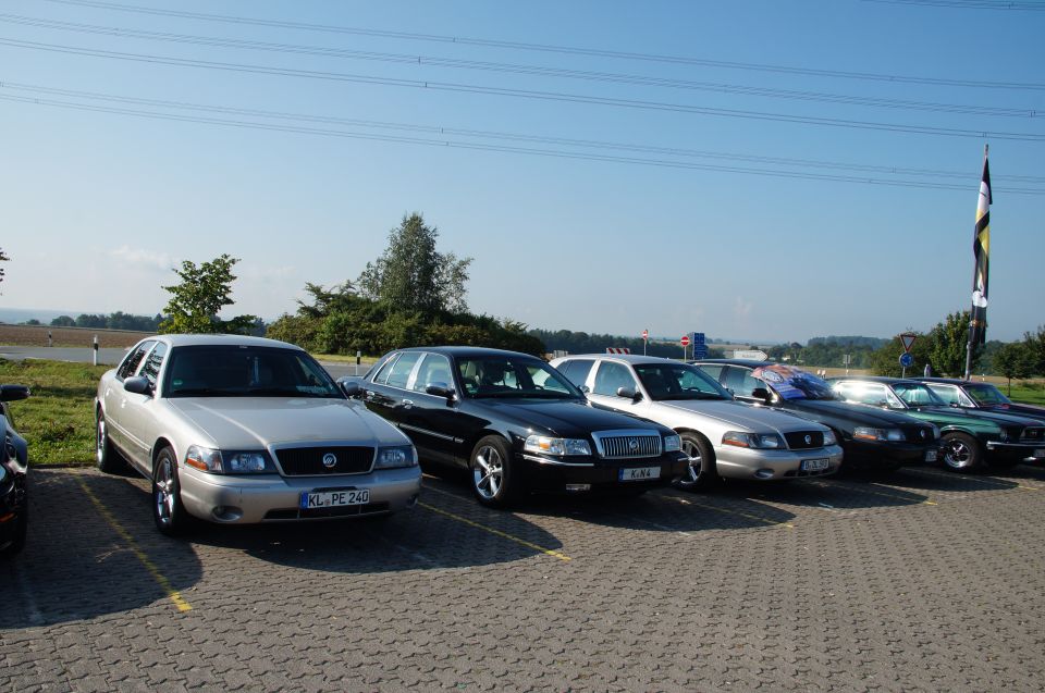 Several Mercury Grand Marquis cars parked in a lot. One has a license plate KL PE 240