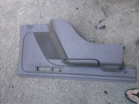 1996 Ford Bronco - A gray plastic car door panel is shown from an interior perspective, lying on a concrete surface.
