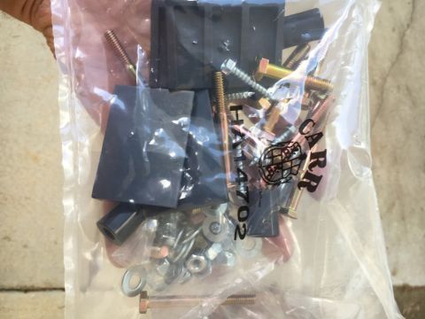 1988 Ford Bronco - A clear plastic bag contains various metal fasteners and black rubber parts, likely for vehicle repair or installation.