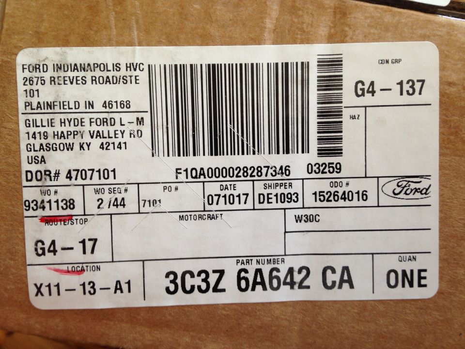 Shipping label on cardboard box with text and barcodes, including part number 3C3Z 6A642 CA