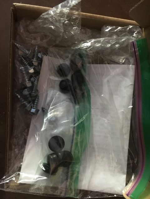 1988 Ford Bronco - Hardware kit with screws and fasteners inside a cardboard box.
