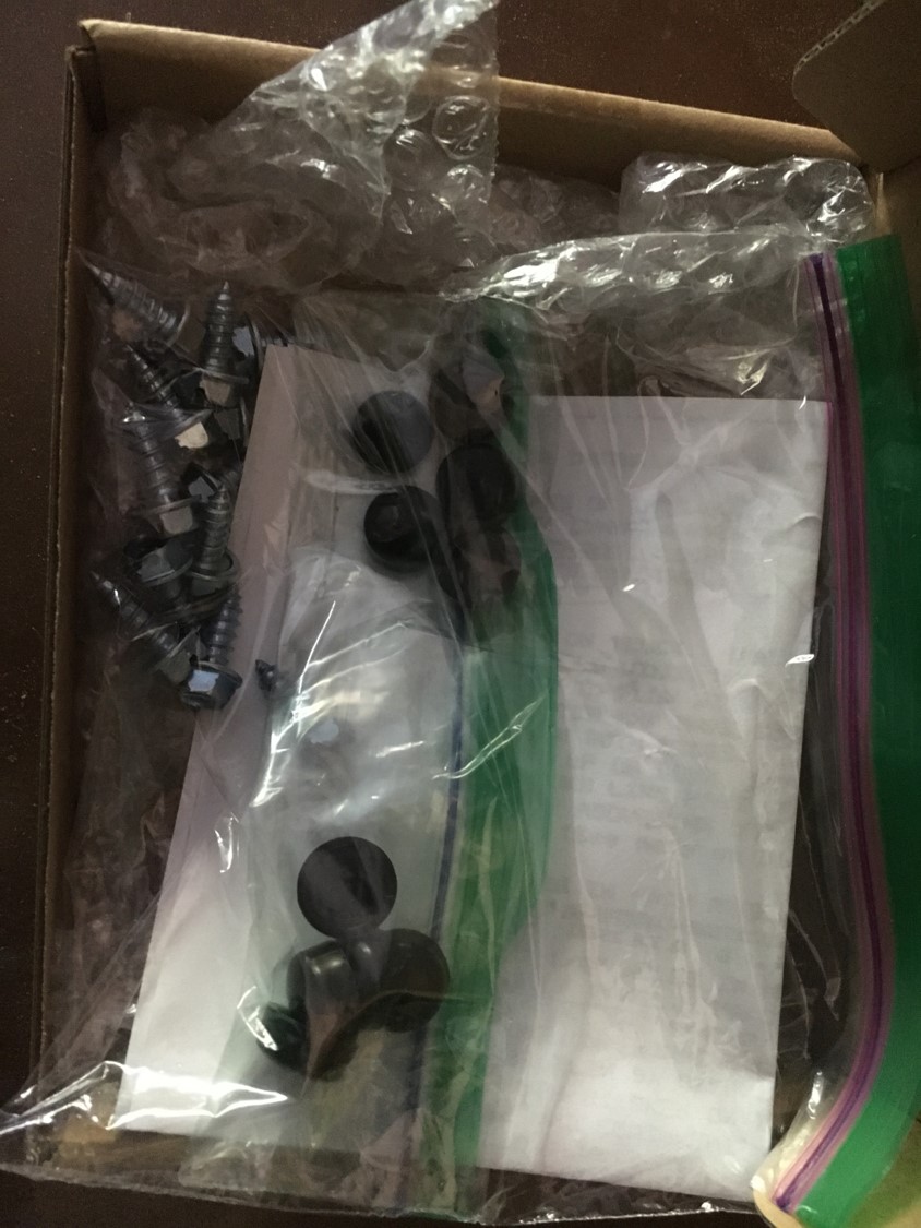 Box containing plastic bags with screws, bolts, and other hardware