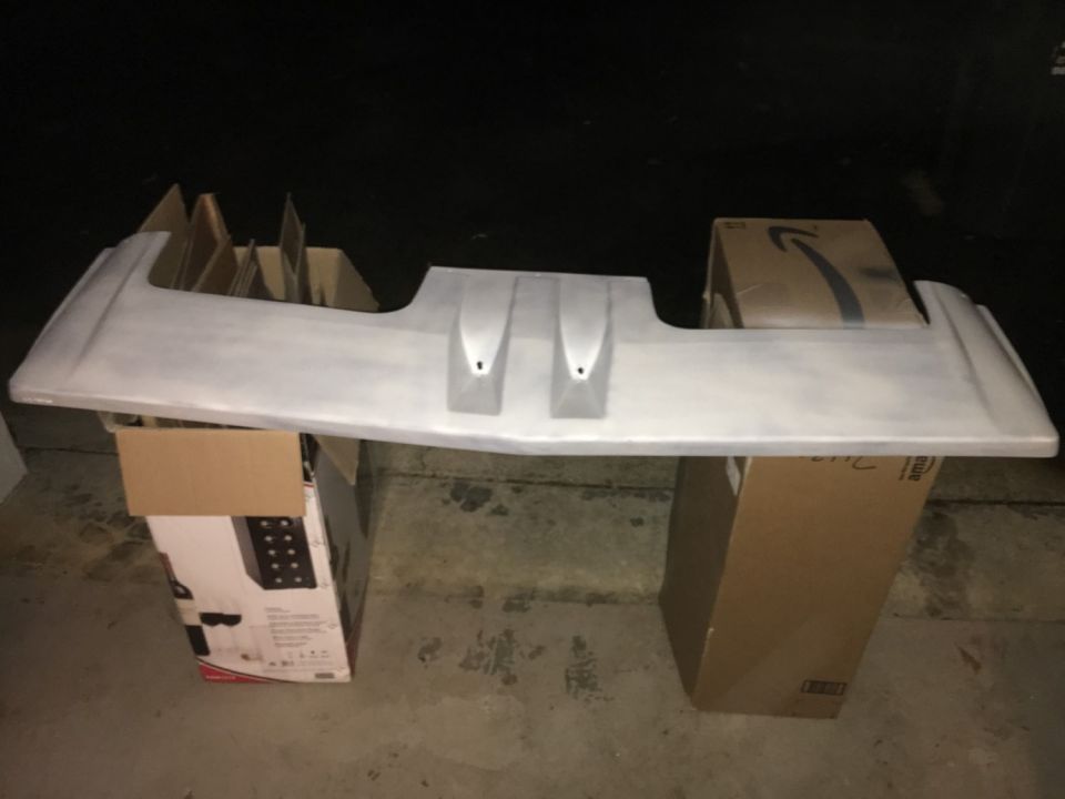 Car spoiler sitting on top of cardboard boxes