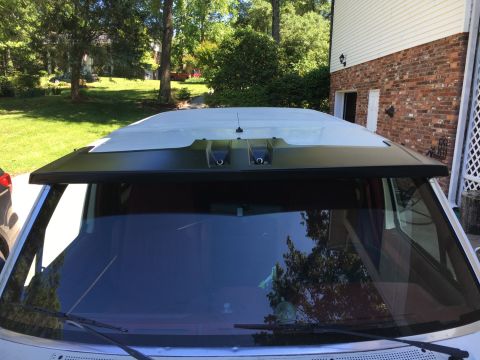 1988 Ford Bronco - The top portion of a white SUV is visible, showing the windshield, roof, and a black visor above the windshield.