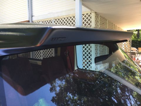 1988 Ford Bronco - The rear spoiler on this SUV is dark and has embossed text visible above the rear window.
