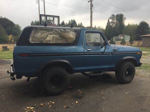 1979 Ford Bronco - Side profile of a blue Ford Bronco, likely a 1978 model, with its windows taped off.