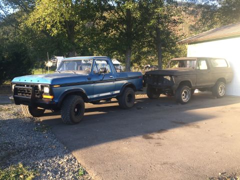 1978 Ford Bronco - Two Ford vehicles, a blue pickup and a Bronco, are parked in front of a garage.