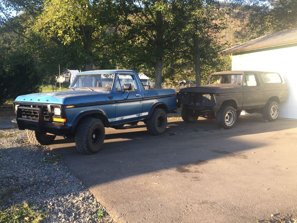 1978 Ford Bronco and a blue Ford pickup truck parked side-by-side