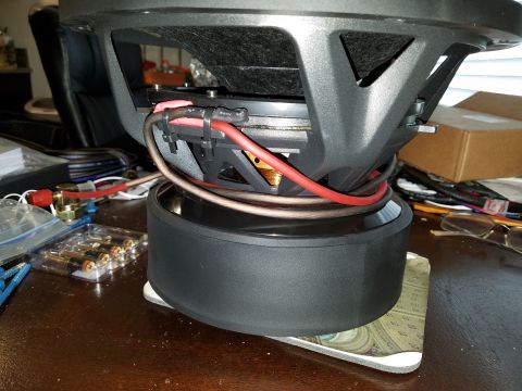 1994 Ford Bronco - Close-up view of a car subwoofer, showing its wiring and connections. The Supermotors logo is visible at the bottom right.