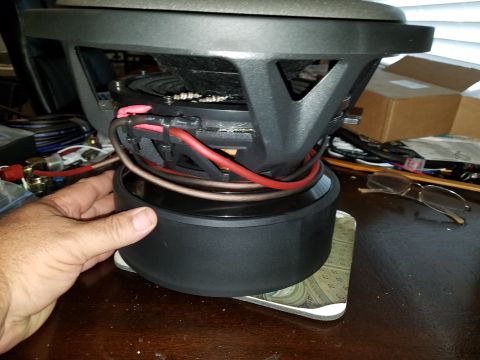 1994 Ford Bronco - A car subwoofer with visible wiring is being held by a hand.