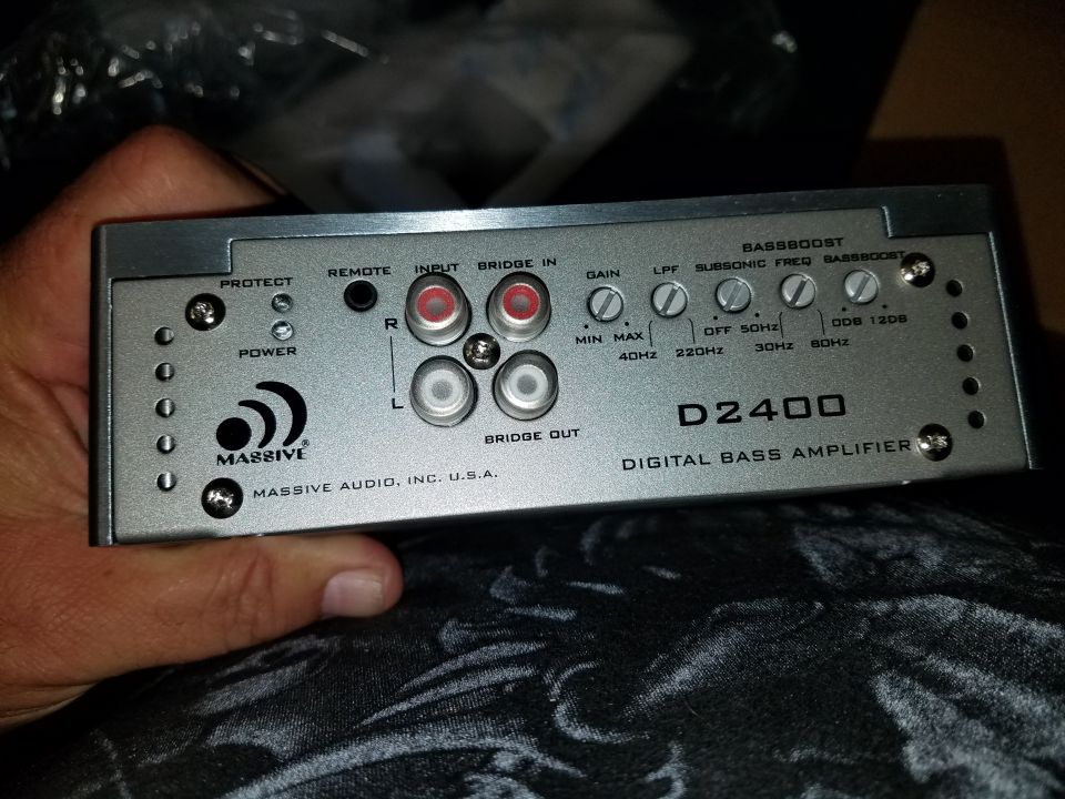 Silver car stereo amplifier with 'MASSIVE' logo and 'D2400 DIGITAL BASS AMPLIFIER' text