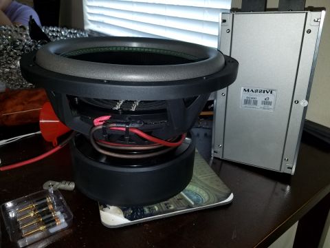 1994 Ford Bronco - A car subwoofer and amplifier are shown on a table, with wiring and connectors nearby.
