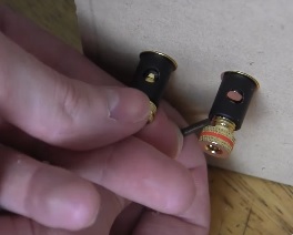 1994 Ford Bronco - Close-up of two stereo connectors, one being held by a person's fingers.