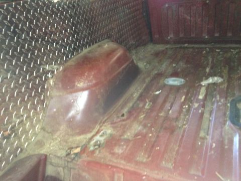 1986 Ford Bronco - The interior cargo area of a 1986 Ford Bronco features diamond plate lining on the side panels and a red-painted floor.