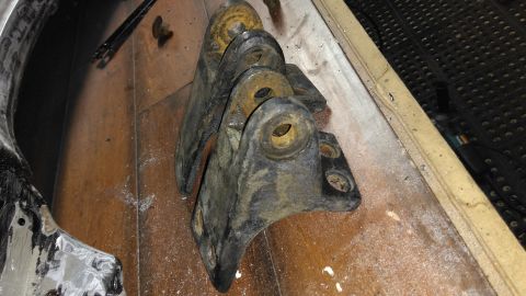 1996 Ford Bronco - These are some old, heavily rusted metal brackets that appear to be parts from a vehicle.