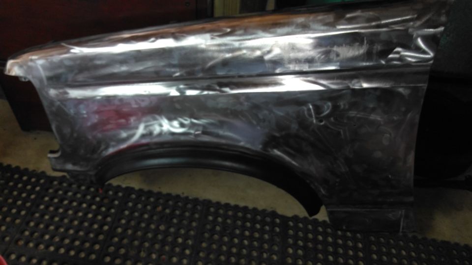 Bare metal fender with visible bodywork damage and primer