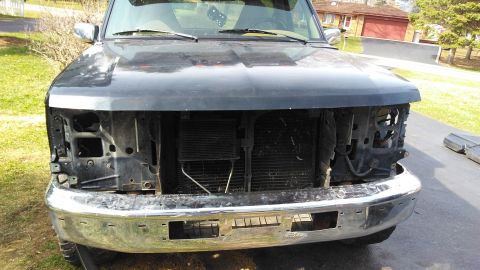 1996 Ford Bronco - The front end of a Ford truck is shown with the grille and headlights removed, exposing the radiator and other components.