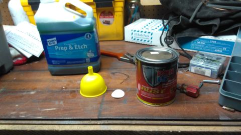 1996 Ford Bronco - Various automotive repair products are arranged on a workbench, suggesting preparation for body work or painting.