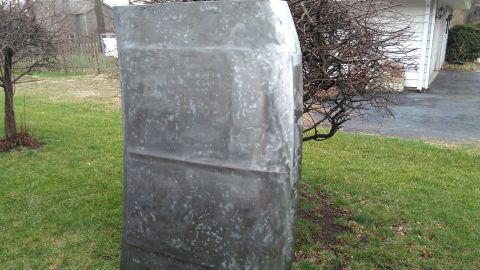 1996 Ford Bronco - A large, unidentifiable metal panel sits outdoors in a grassy area next to a tree.