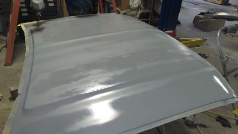 1996 Ford Bronco - A car hood is being sanded and prepped for paint in a workshop setting.