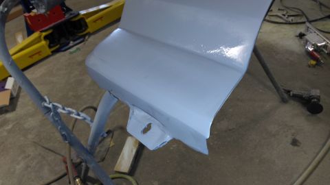 1996 Ford Bronco - A car door panel is being prepped for paint in a workshop environment.