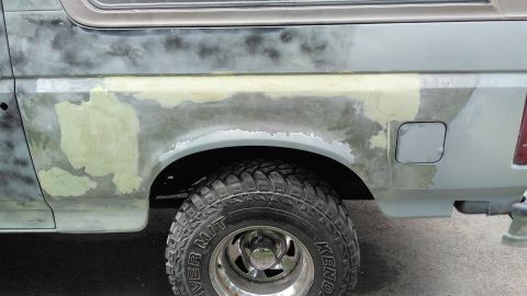 1996 Ford Bronco - The vehicle is undergoing body work, with visible patches of primer and filler on its side.