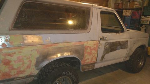 1996 Ford Bronco - This 1996 Ford Bronco is shown during bodywork, with primer and repair patches visible on its side.
