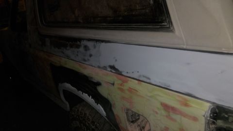 1996 Ford Bronco - The vehicle's body is being prepped for paint, with visible areas of primer and filler.