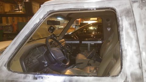 1996 Ford Bronco - The interior of a 1996 Ford Bronco shows a gray primer finish and dice hanging from the rearview mirror.