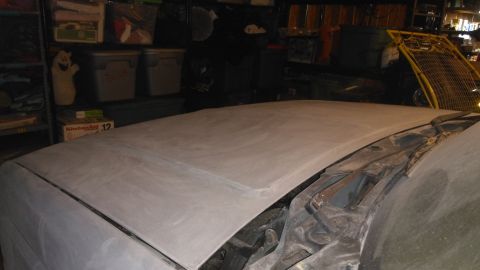 1996 Ford Bronco - The hood of a vehicle is covered in primer, ready for paint, with windshield wipers visible.