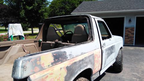 1996 Ford Bronco - 1996 Ford Bronco body in primer, showing bodywork in progress. The rear section and interior are visible.